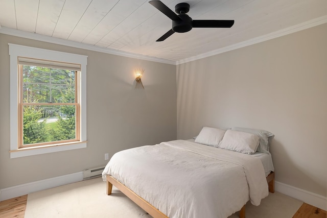 bedroom featuring a baseboard radiator, ornamental molding, baseboards, wood finished floors, and ceiling fan