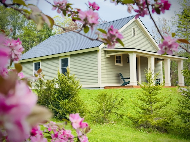 view of property exterior featuring metal roof and covered porch