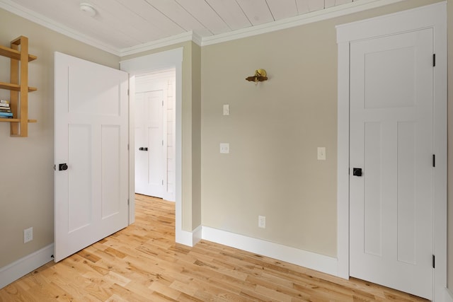 spare room with crown molding, light wood finished floors, baseboards, and a smoke detector