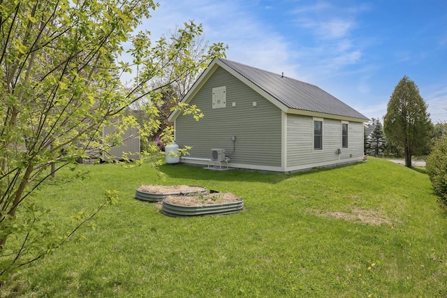 view of side of home featuring a yard and metal roof