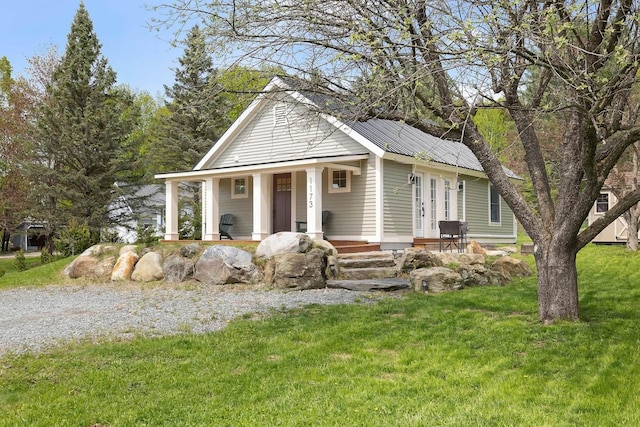view of front of home with a porch, a front yard, and metal roof