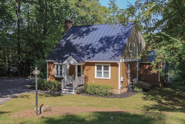 111 Shore Dr, Henniker, NH 03242 - cape cod home with a standing seam roof, a chimney, a front lawn, and metal roof