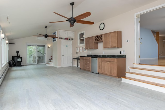 111 Shore Dr, Henniker, NH 03242 - kitchen featuring a wood stove, a ceiling fan, light wood-style floors, and high vaulted ceiling