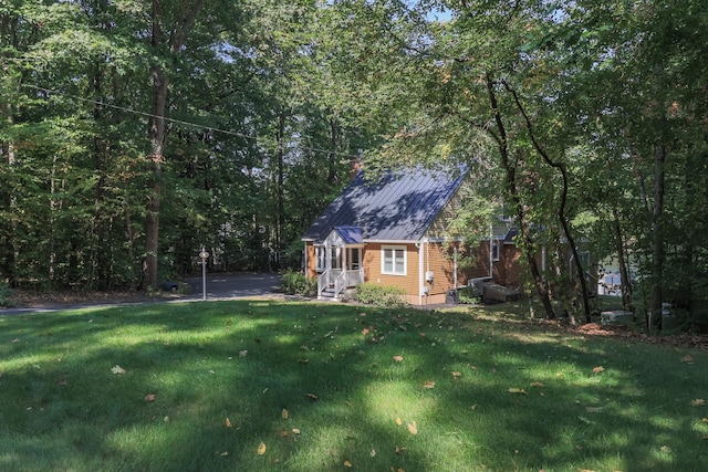 111 Shore Dr, Henniker, NH 03242 - view of home's exterior with a yard, metal roof, and a view of trees