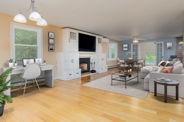 111 Shore Dr, Henniker, NH 03242 - living area with a baseboard radiator, light wood finished floors, and a ceiling fan