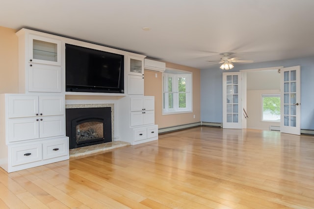 111 Shore Dr, Henniker, NH 03242 - unfurnished living room with a wall mounted air conditioner, a baseboard radiator, french doors, light wood-style flooring, and a ceiling fan