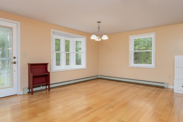 111 Shore Dr, Henniker, NH 03242 - empty room with a chandelier, light wood-style floors, and a baseboard heating unit