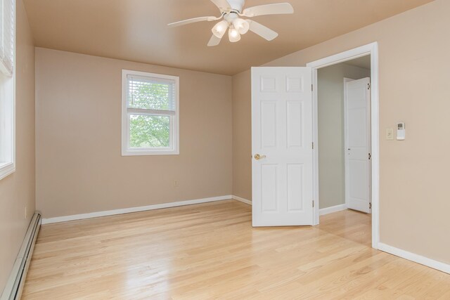 111 Shore Dr, Henniker, NH 03242 - unfurnished bedroom featuring baseboard heating, light wood-type flooring, baseboards, and a ceiling fan