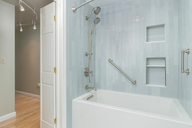 111 Shore Dr, Henniker, NH 03242 - bathroom with washtub / shower combination, wood finished floors, and baseboards