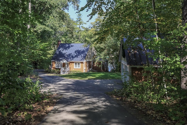 111 Shore Dr, Henniker, NH 03242 - view of front of home featuring driveway, a chimney, metal roof, and a front lawn