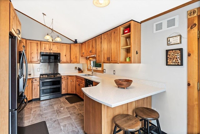 8 Bowman Ct, Merrimack, NH 03054 - kitchen with black appliances, a peninsula, a sink, light countertops, and lofted ceiling