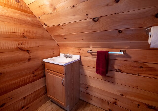 334 Silver Pine Ln, Tamworth, NH 03886 - bathroom featuring wooden walls, vanity, and wood finished floors