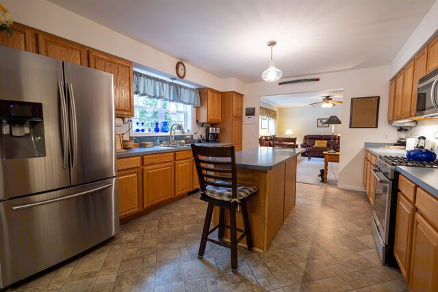 334 Silver Pine Ln, Tamworth, NH 03886 - kitchen with stainless steel appliances, dark countertops, a sink, stone finish flooring, and a center island