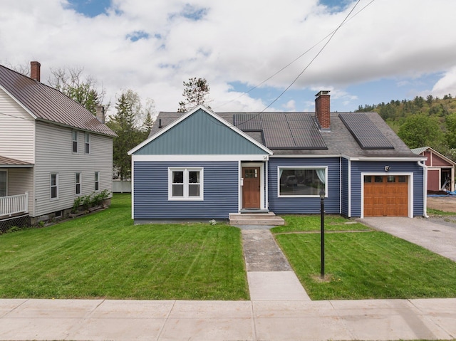 14 Butler St, Waterbury, VT 05676 - view of front of house with an attached garage, roof mounted solar panels, concrete driveway, a chimney, and a front yard