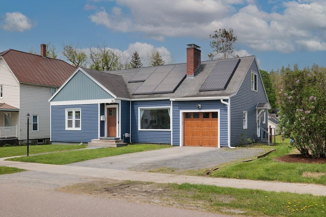 14 Butler St, Waterbury, VT 05676 - view of front facade with a garage, a chimney, solar panels, a front lawn, and driveway