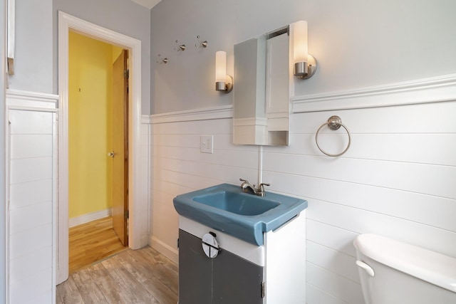 14 Butler St, Waterbury, VT 05676 - bathroom with wood finished floors, toilet, vanity, and a wainscoted wall