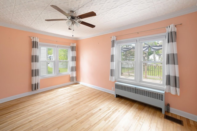 14 Butler St, Waterbury, VT 05676 - empty room featuring radiator heating unit, crown molding, hardwood / wood-style flooring, baseboards, and a ceiling fan