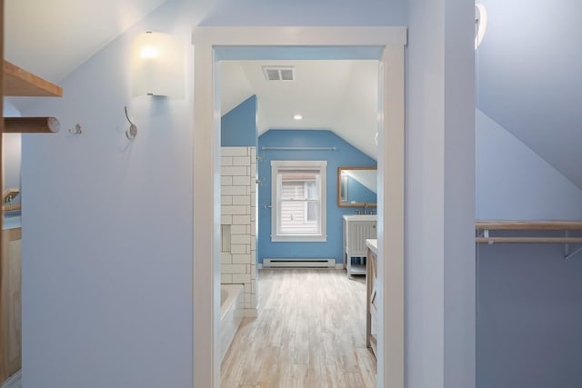 14 Butler St, Waterbury, VT 05676 - hallway with baseboard heating, lofted ceiling, wood finished floors, and a sink