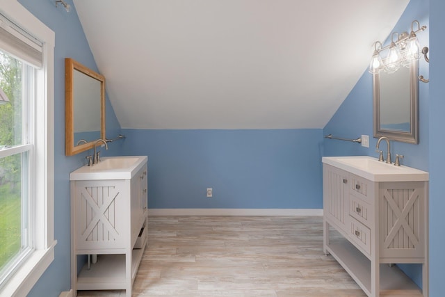 14 Butler St, Waterbury, VT 05676 - full bathroom featuring vaulted ceiling, two vanities, wood finished floors, and baseboards