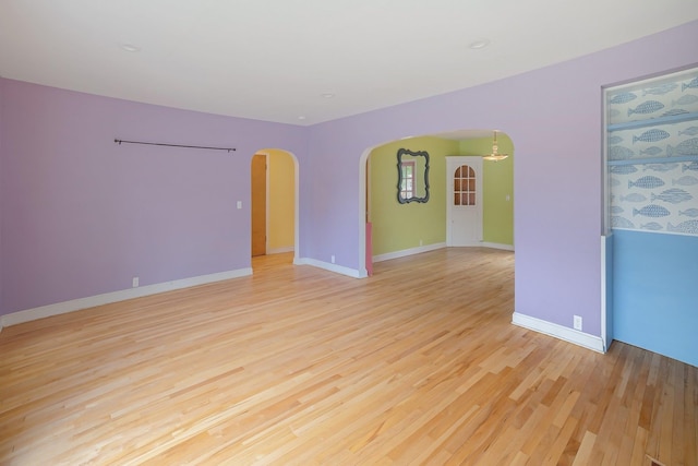 14 Butler St, Waterbury, VT 05676 - empty room with arched walkways, light wood finished floors, and baseboards