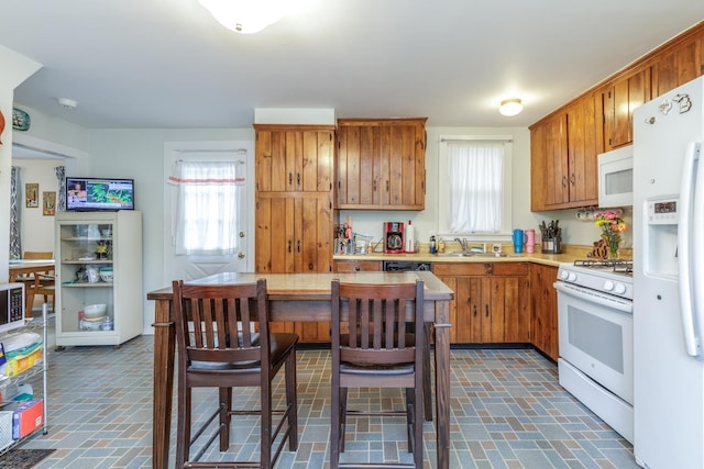 33 Tanner St, Concord, NH 03303 - kitchen featuring white appliances, brick patterned floors, light countertops, and brown cabinetry