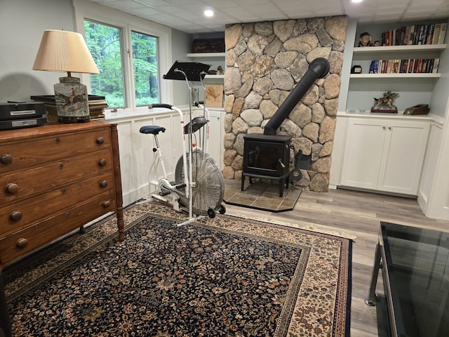 46 Point Breeze Rd, Wolfeboro, NH 03894 - exercise area featuring a wood stove, light wood-style flooring, and a paneled ceiling