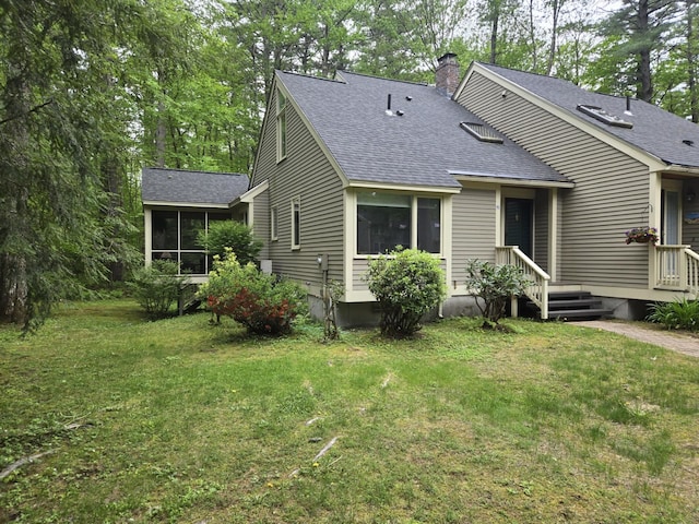 46 Point Breeze Rd, Wolfeboro, NH 03894 - view of front of house featuring roof with shingles, a sunroom, a chimney, and a front yard