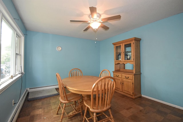 dining space with a baseboard heating unit, ceiling fan, and baseboards
