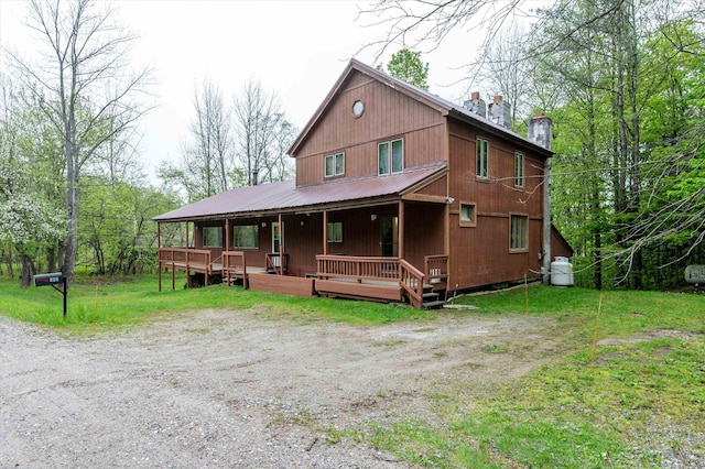143 Okemo Acres, Ludlow, VT 05149 - view of front of house with a porch, a chimney, and metal roof