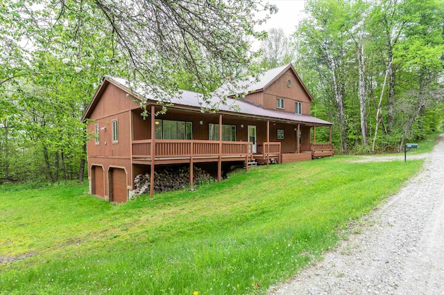 143 Okemo Acres, Ludlow, VT 05149 - view of front facade with driveway, a front yard, covered porch, metal roof, and a garage