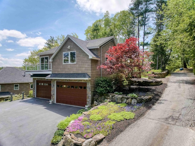 25 N Shore Rd, Windham, NH 03087 - view of front of property with a garage, asphalt driveway, a shingled roof, a balcony, and stone siding