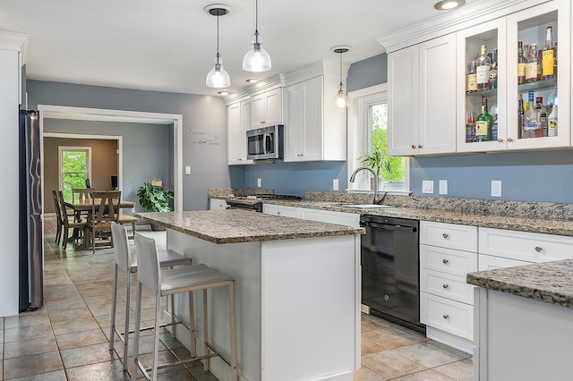 105 Fall Mill Rd, York, ME 03909 - kitchen featuring appliances with stainless steel finishes, white cabinetry, a sink, a kitchen island, and a breakfast bar area