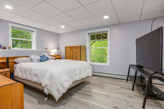 105 Fall Mill Rd, York, ME 03909 - bedroom with a baseboard radiator, light wood-style flooring, multiple windows, a paneled ceiling, and recessed lighting