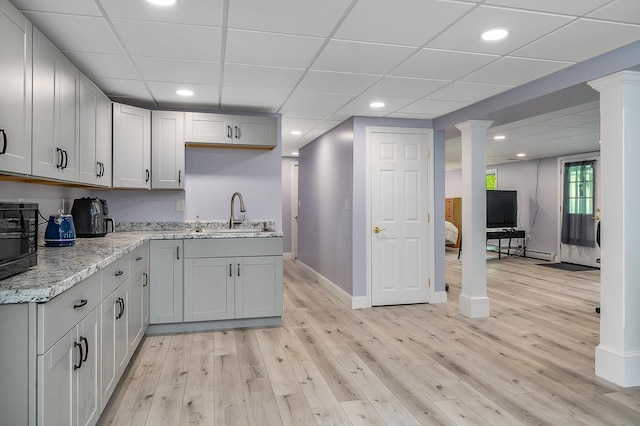 105 Fall Mill Rd, York, ME 03909 - kitchen featuring a sink, light wood-style flooring, baseboards, light stone countertops, and ornate columns
