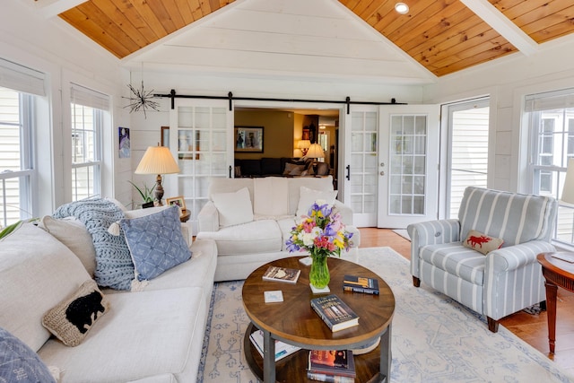 104 Champagne Cir, Campton, NH 03223 - living area featuring vaulted ceiling, a barn door, wooden ceiling, plenty of natural light, and light wood finished floors