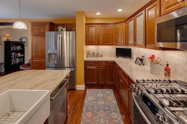 104 Champagne Cir, Campton, NH 03223 - kitchen with stainless steel appliances, dark wood-style floors, brown cabinetry, glass insert cabinets, and light stone countertops