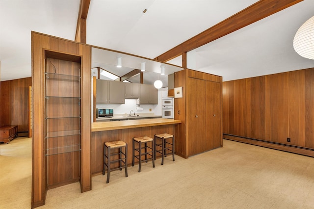 25 Wendover Way, Bedford, NH 03110 - kitchen with wood counters, a baseboard heating unit, a kitchen bar, wooden walls, and light carpet