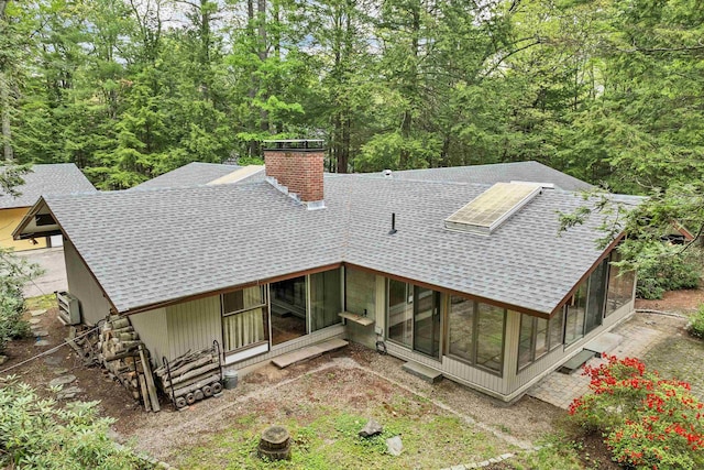25 Wendover Way, Bedford, NH 03110 - back of house with roof with shingles, a sunroom, and a chimney
