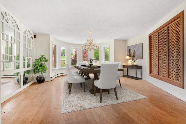 43 Sterling Pl, Bow, NH 03304 - dining area featuring wallpapered walls, a chandelier, wood finished floors, a textured ceiling, and baseboards
