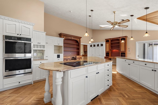 43 Sterling Pl, Bow, NH 03304 - kitchen with black electric stovetop, stainless steel double oven, open shelves, ceiling fan, and lofted ceiling