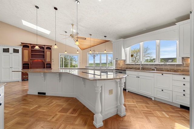 43 Sterling Pl, Bow, NH 03304 - kitchen featuring vaulted ceiling, electric cooktop, a skylight, a sink, and plenty of natural light