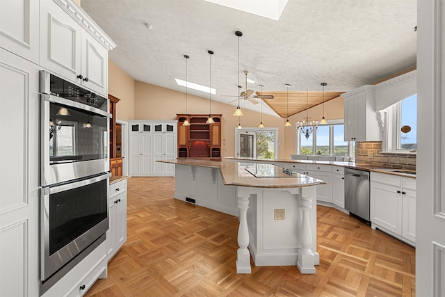 43 Sterling Pl, Bow, NH 03304 - kitchen with stainless steel appliances, a skylight, vaulted ceiling, a textured ceiling, and a breakfast bar area