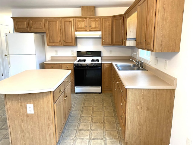 32 Henry Taylor St, Salem, NH 03079 - kitchen featuring range with gas stovetop, a sink, freestanding refrigerator, under cabinet range hood, and light countertops