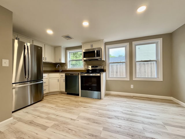 3 Lyndale Ave, Salem, NH 03079 - kitchen with stainless steel appliances, white cabinets, dark countertops, baseboards, and light wood-style flooring