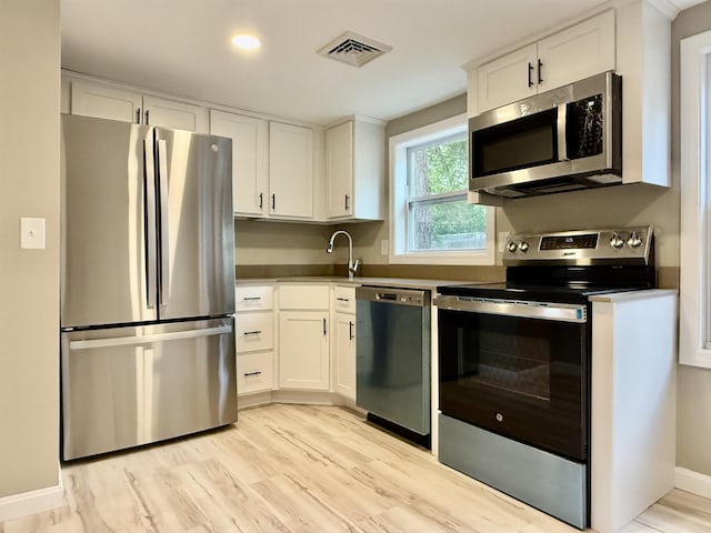 3 Lyndale Ave, Salem, NH 03079 - kitchen with stainless steel appliances, white cabinets, light wood-style flooring, and a sink
