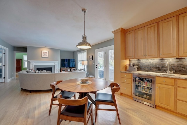 155 Middle Rd, Brentwood, NH 03833 - dining space with wine cooler, bar with sink, light wood-style flooring, and a fireplace