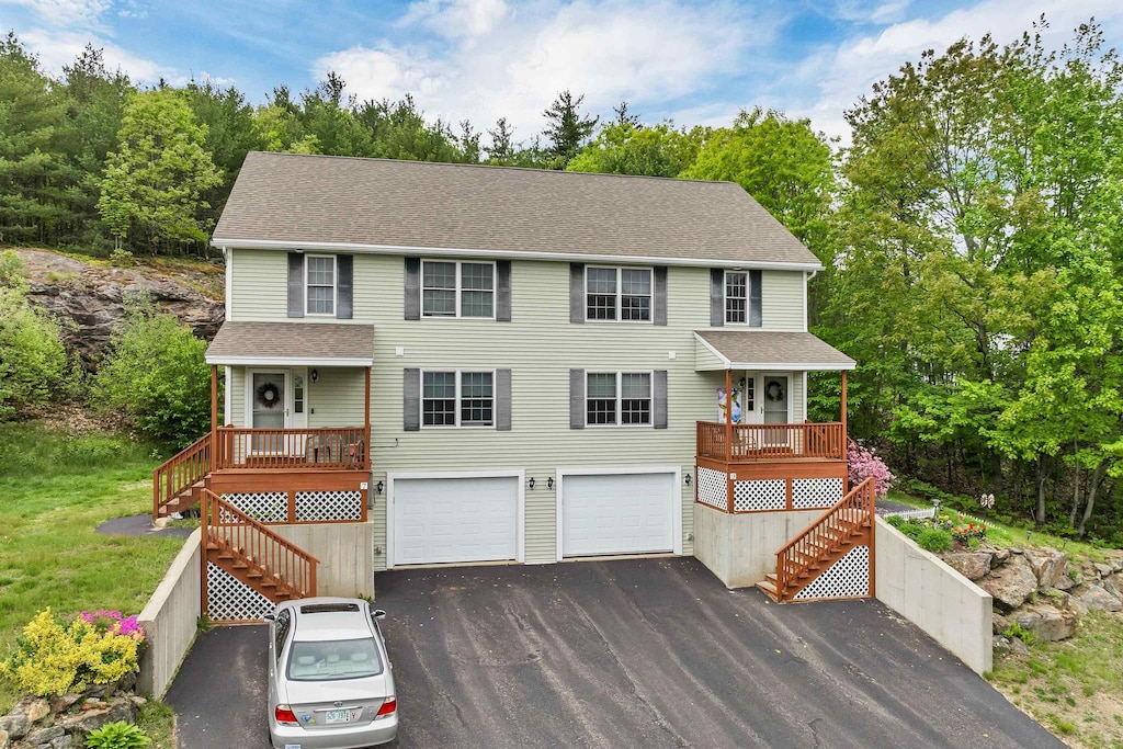 9 Omalley Dr, Milton, NH 03851 - view of front of home featuring stairway, an attached garage, driveway, a shingled roof, and view of wooded area