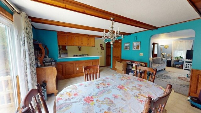 1862 Hooksett Rd, Hooksett, NH 03106 - dining room featuring beamed ceiling, arched walkways, a chandelier, and light colored carpet