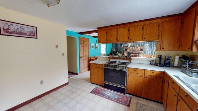 1862 Hooksett Rd, Hooksett, NH 03106 - kitchen with electric stove, brown cabinets, light floors, and light countertops
