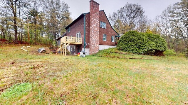 1862 Hooksett Rd, Hooksett, NH 03106 - view of home's exterior featuring a chimney, a wooden deck, and stairs